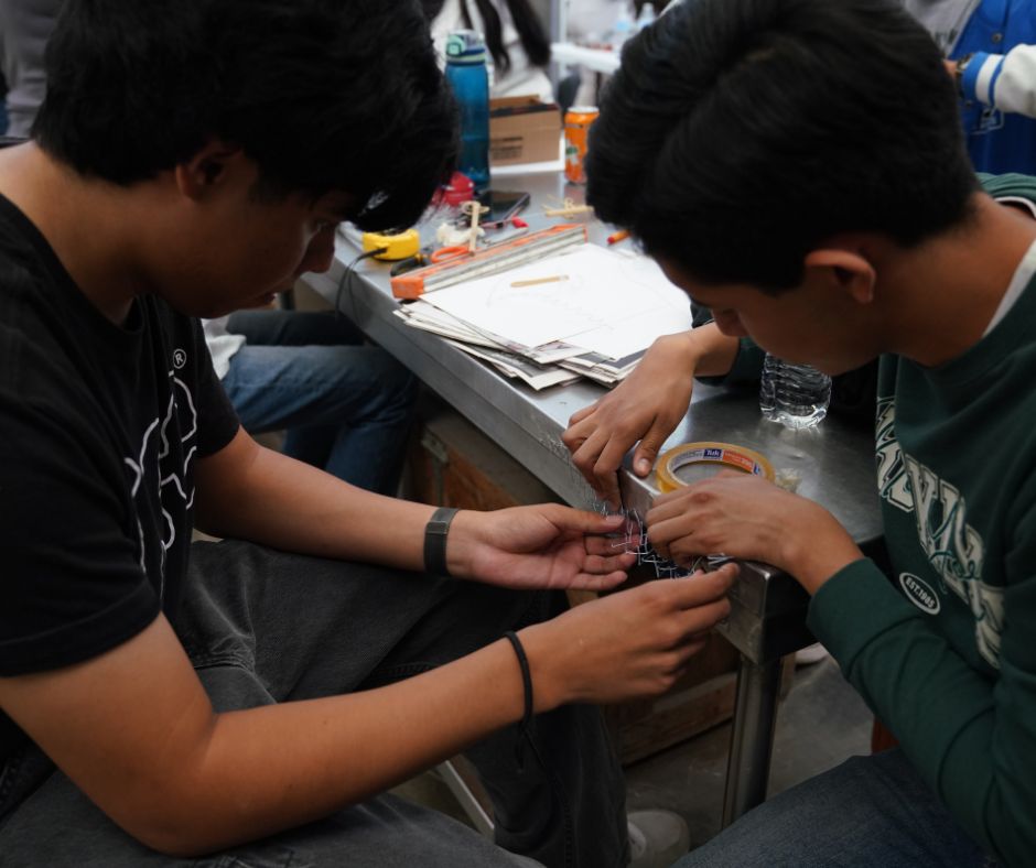 Estudiantes de ingeniería civil construyendo barreras dinámicas a escala